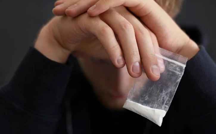 Person holding a small bag of drugs, illustrating common drug possession defenses in Florida.
