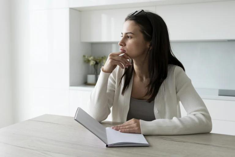 Woman thoughtfully considering how to hire a lawyer in Florida while holding a notebook.