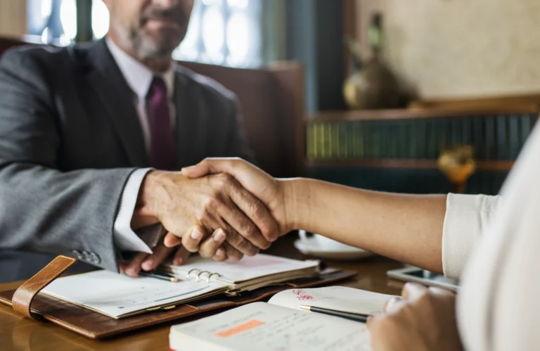 Nonprofit attorney shaking hands with a client after being hired.