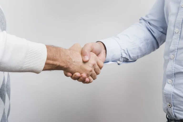 Two people shaking hands, symbolizing verbal contracts and informal business agreements.